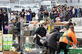 japanese earthquake survivors wait patiently for supplies.