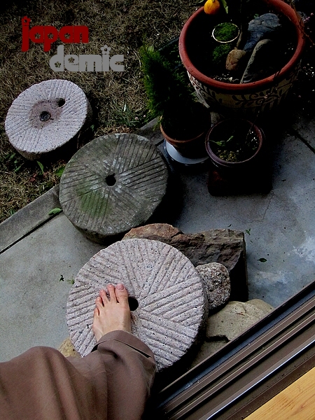 ishi-usu-millstones-stepping450 Foot stepping onto Japanese granite buckwheat millstone steps.